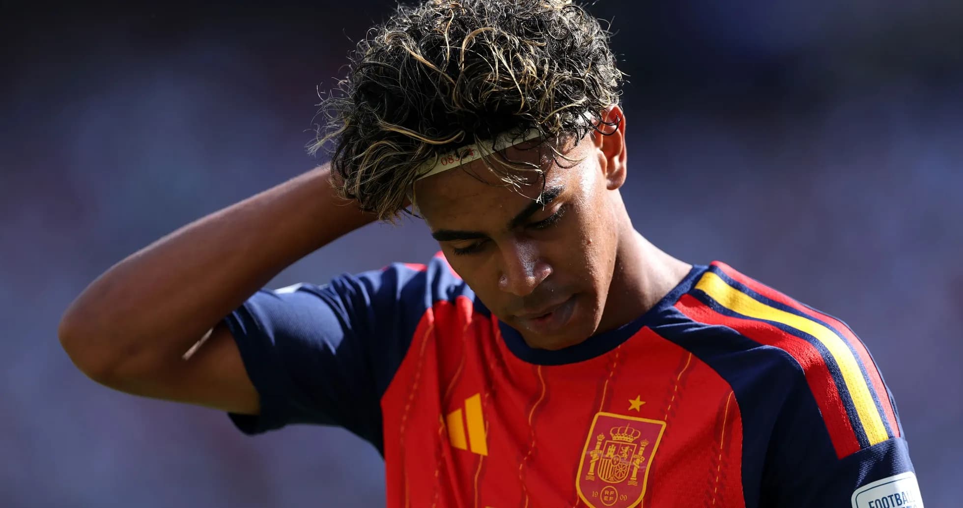 Jugador de España con camiseta roja, mirando hacia abajo