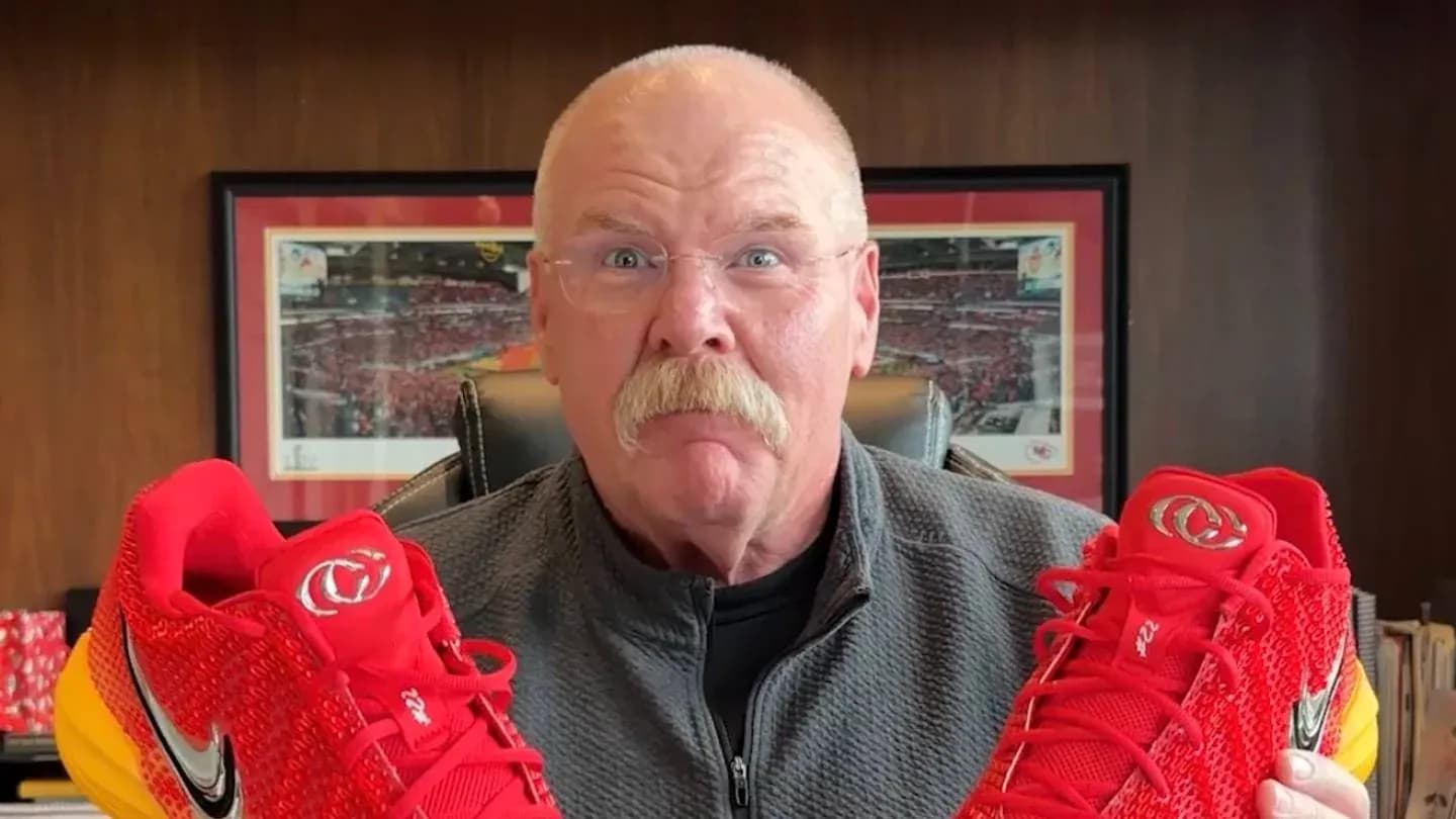 Hombre sosteniendo zapatillas Nike rojas en oficina