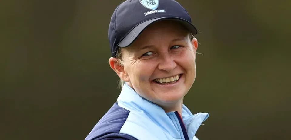 Jugadora de cricket sonriendo durante un evento