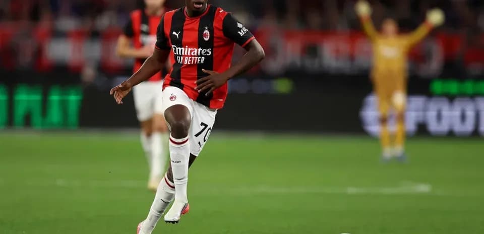Jugador de AC Milan corriendo con el balón en el campo