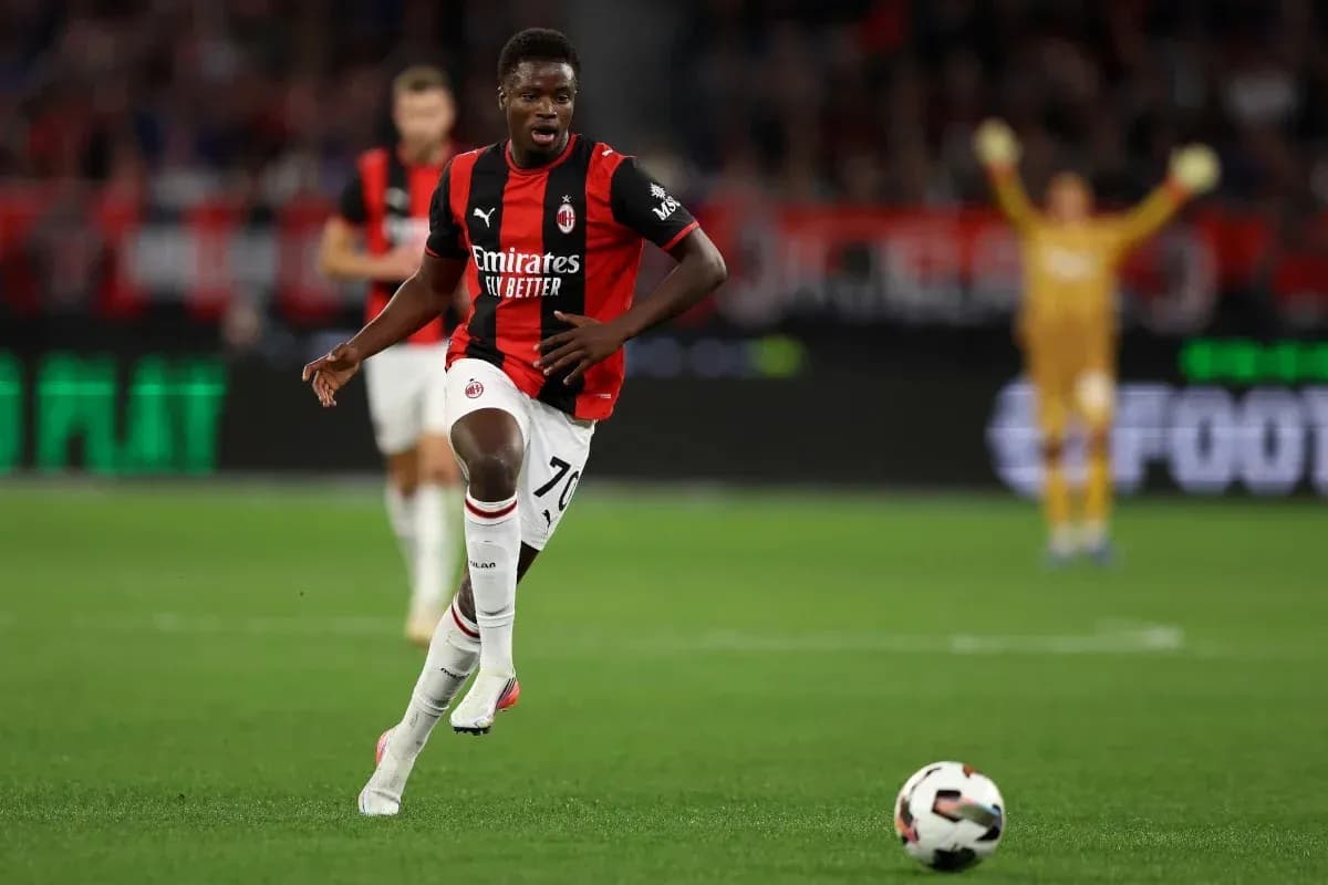 Jugador de AC Milan corriendo con el balón en el campo