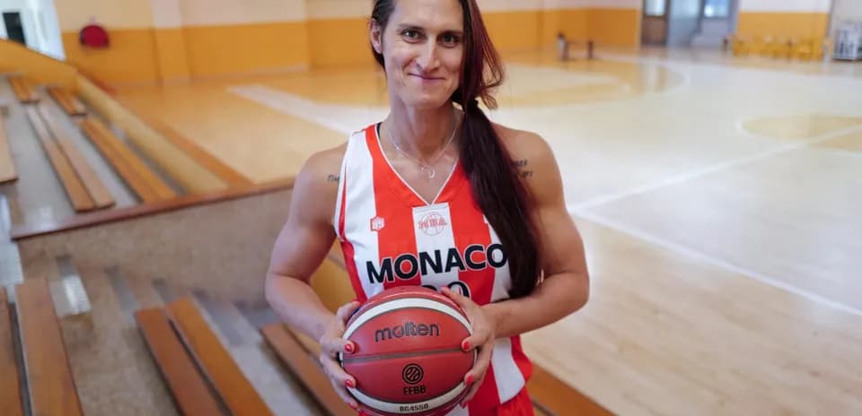 Jugadora de baloncesto sosteniendo una pelota en cancha