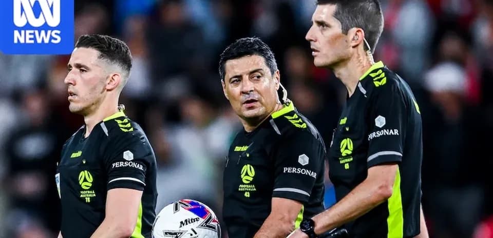 Tres árbitros discutiendo durante un partido de fútbol