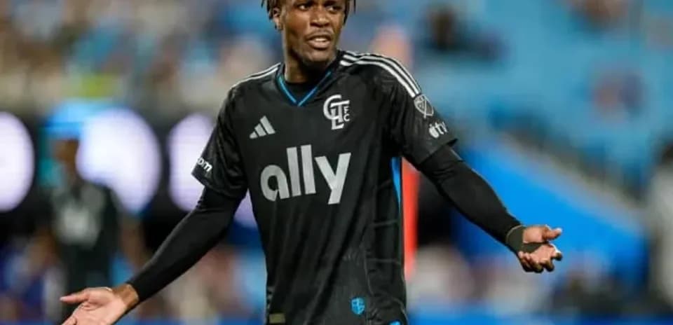 Jugador en camiseta negra gesticulando en el campo