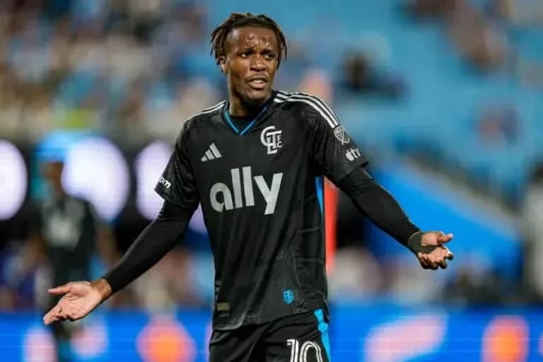 Jugador en camiseta negra gesticulando en el campo