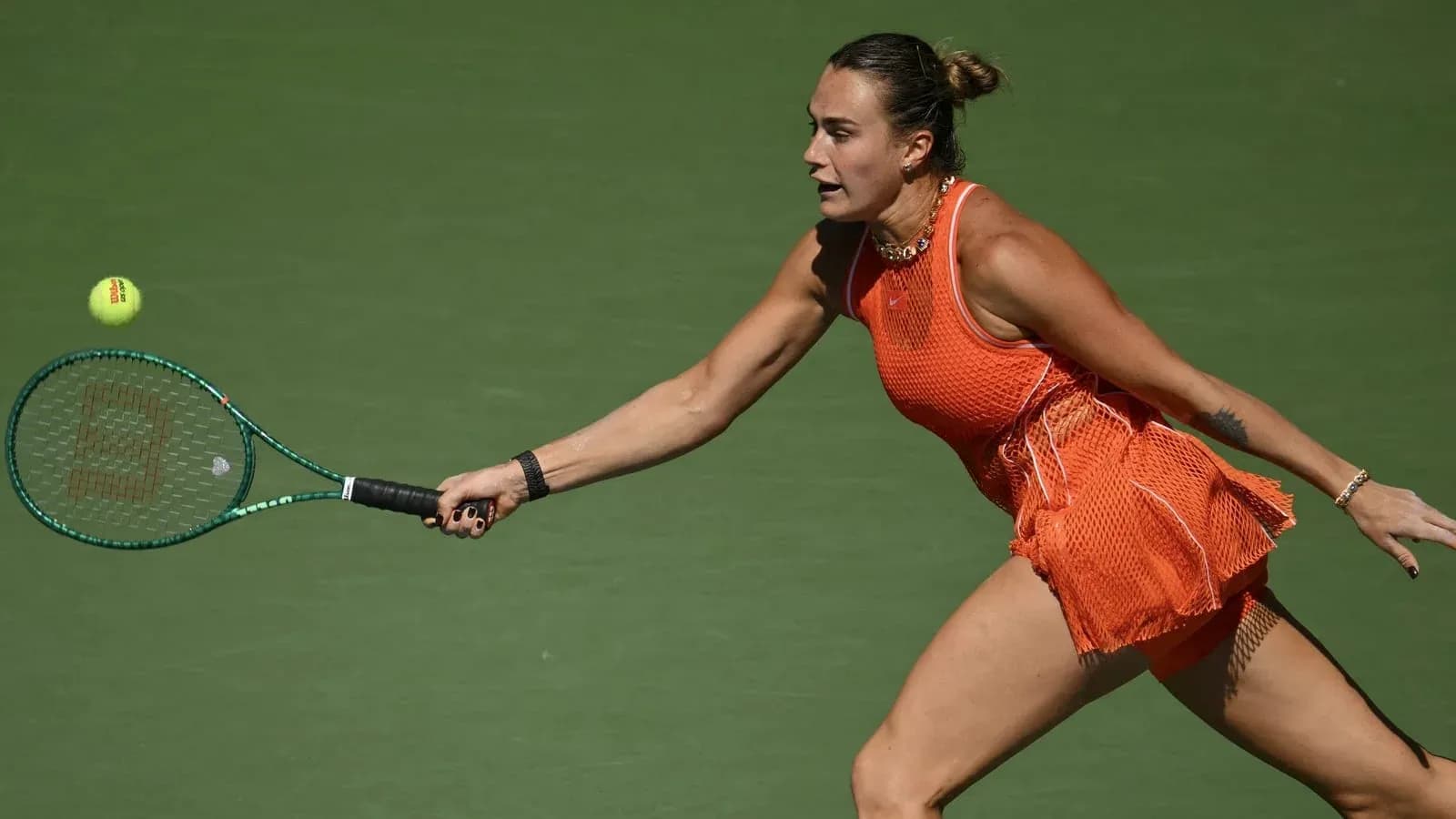Jugadora de tenis golpeando una pelota en la cancha