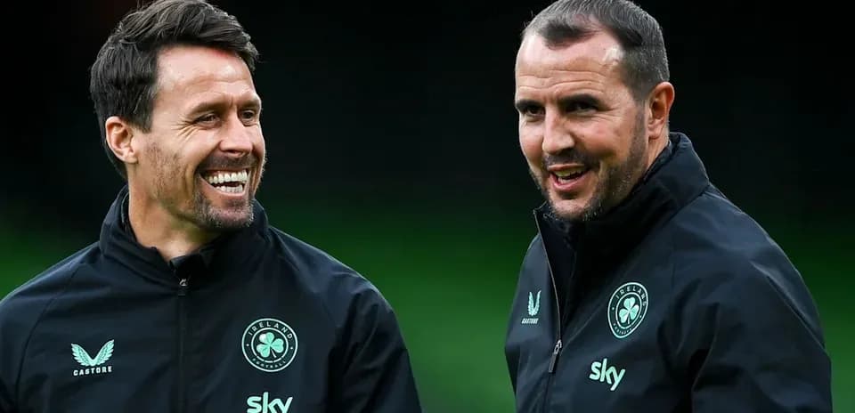 Dos entrenadores conversando en el campo de entrenamiento
