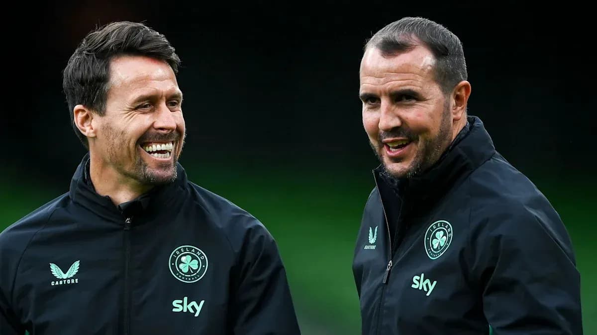 Dos entrenadores conversando en el campo de entrenamiento