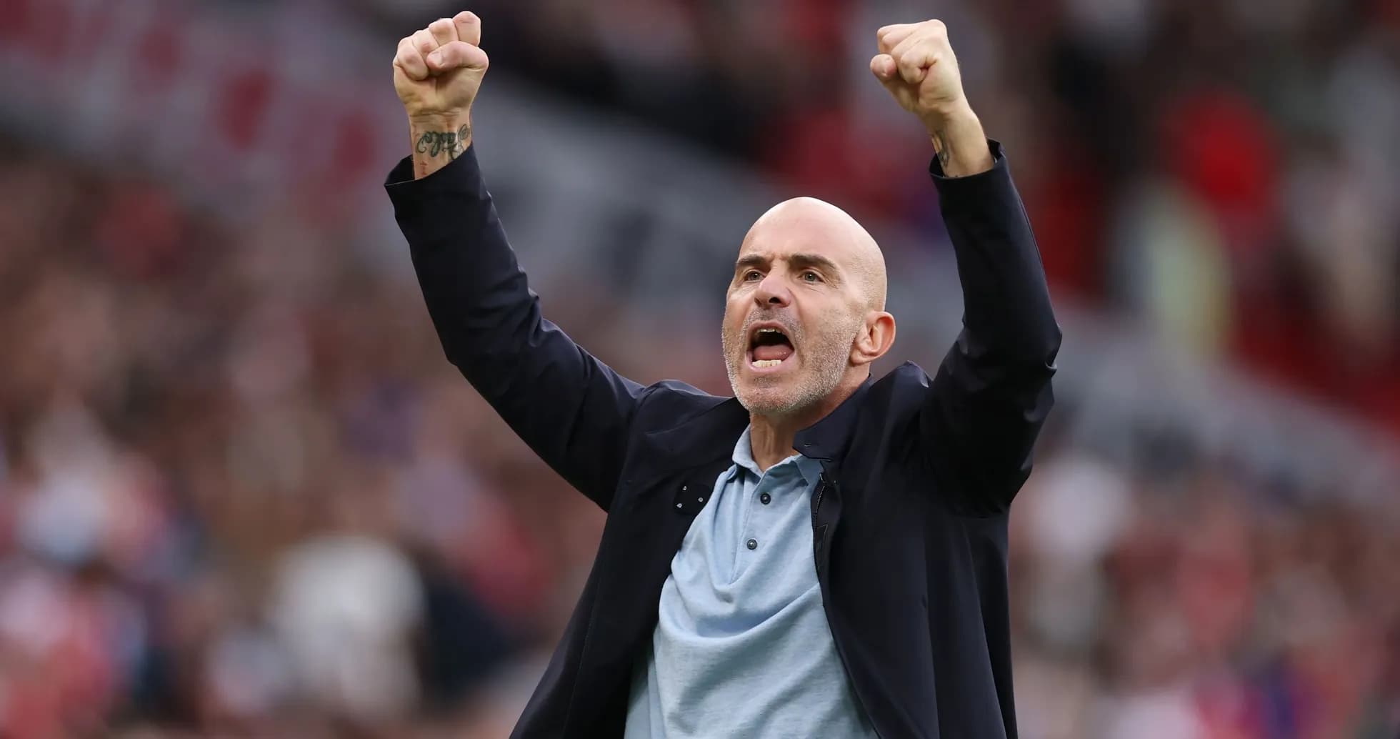 Entrenador celebrando con los brazos en alto