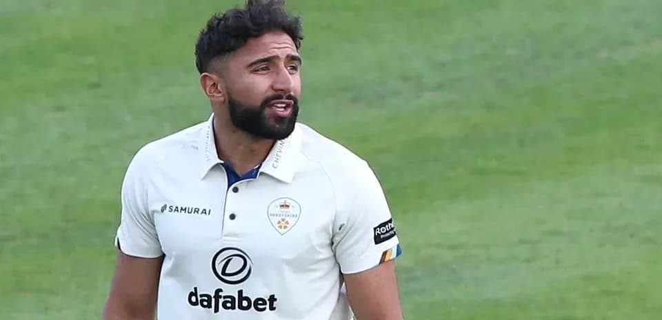 Jugador de cricket en uniforme hablando en el campo