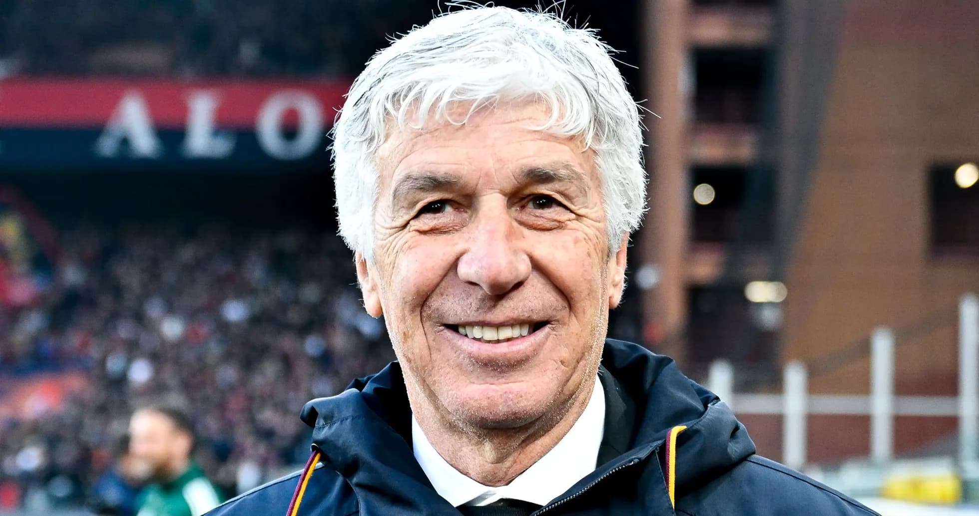 Entrenador sonriendo en el estadio durante partido