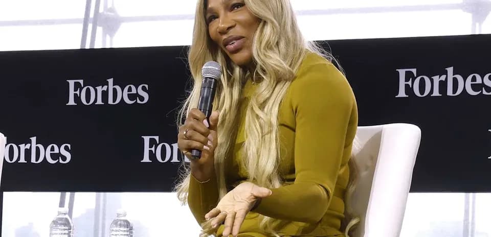 Mujer hablando con micrófono en evento de Forbes