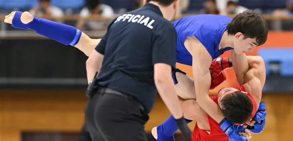 Luchadores en combate durante torneo de artes marciales