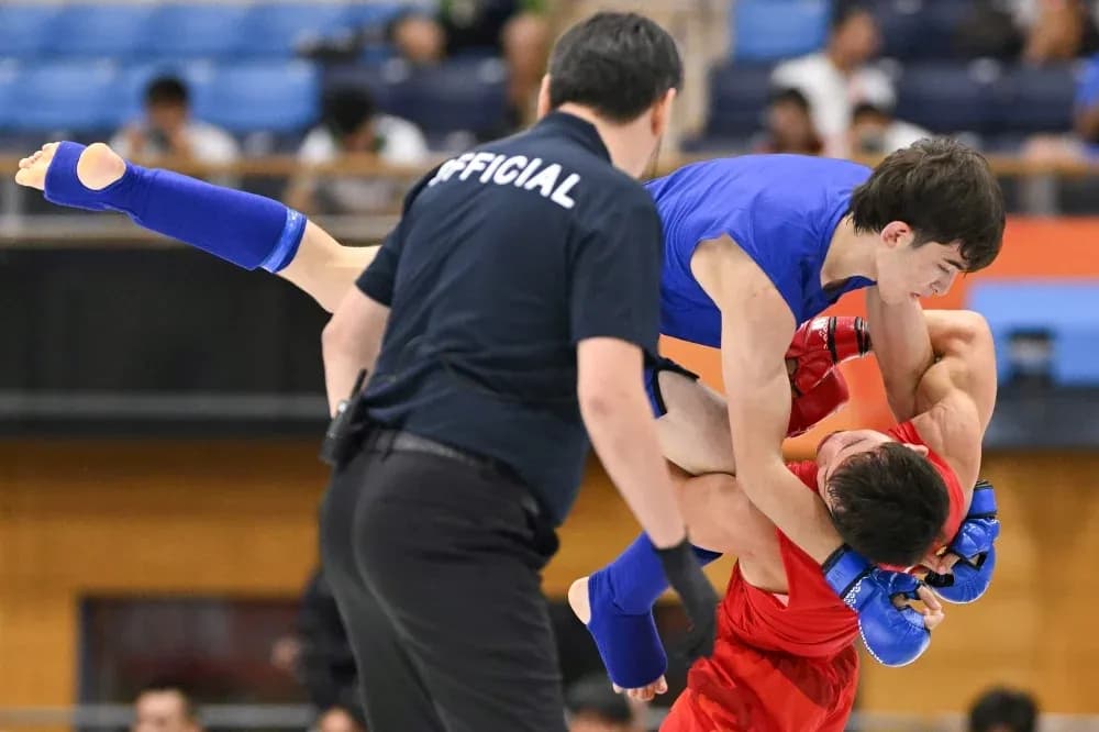 Luchadores en combate durante torneo de artes marciales