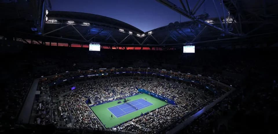 Estadio lleno durante partido de tenis nocturno