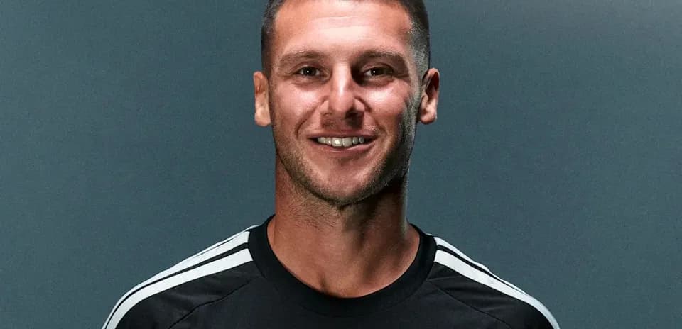 Jugador sonriendo con camiseta negra de equipo