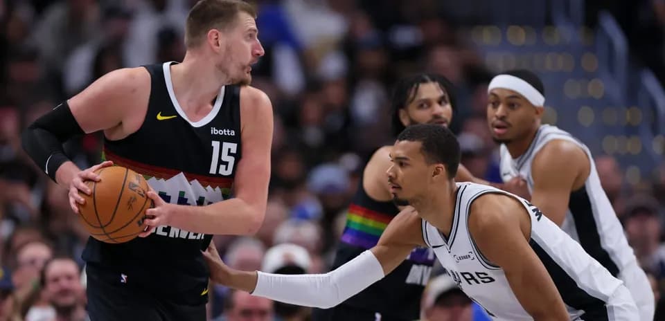 Jugador de Denver driblando mientras es defendido por San Antonio