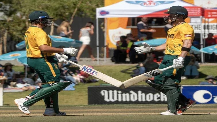 Jugadores de cricket chocando sus bates en el campo