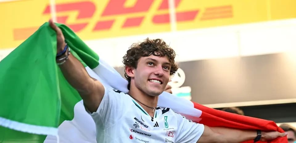 Piloto con bandera italiana celebrando en el podio
