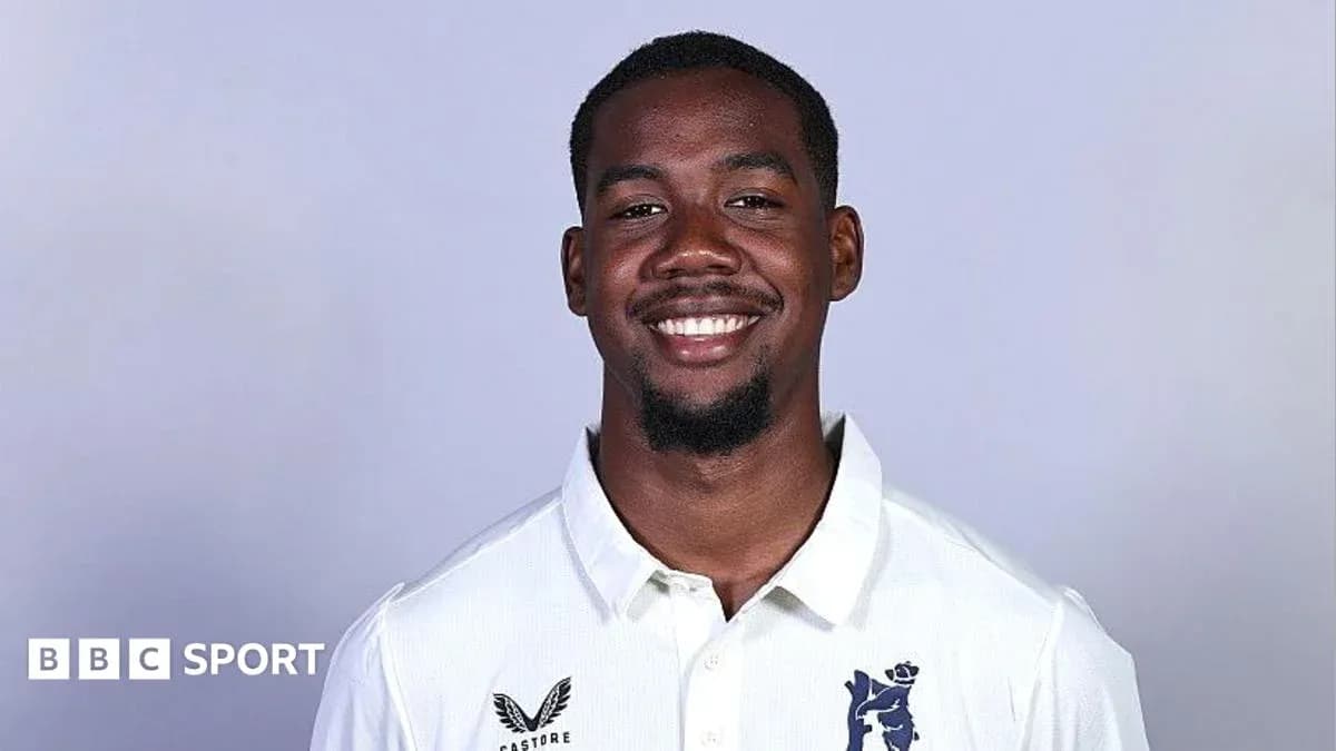 Jugador sonriendo con camiseta blanca de cricket