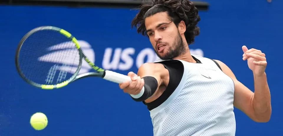 Jugador de tenis golpeando una pelota en la cancha