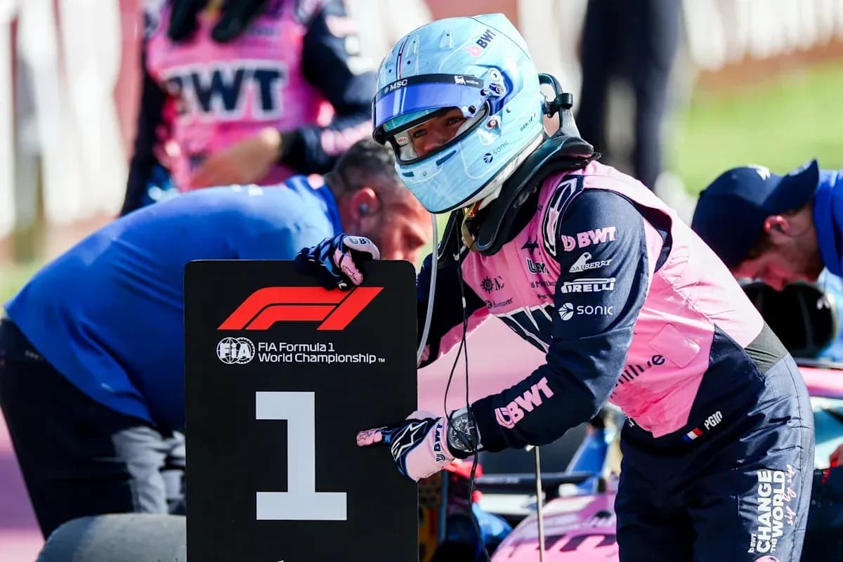 Piloto señalando el cartel número uno en carrera