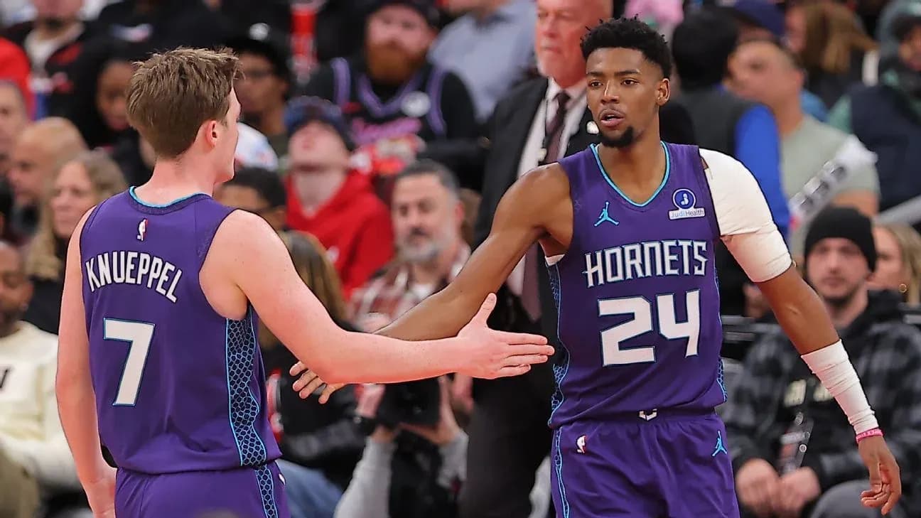 Jugadores de los Hornets chocando manos en partido