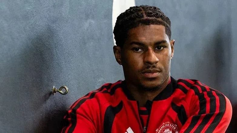 Jugador sentado en vestuario con camiseta de Manchester United