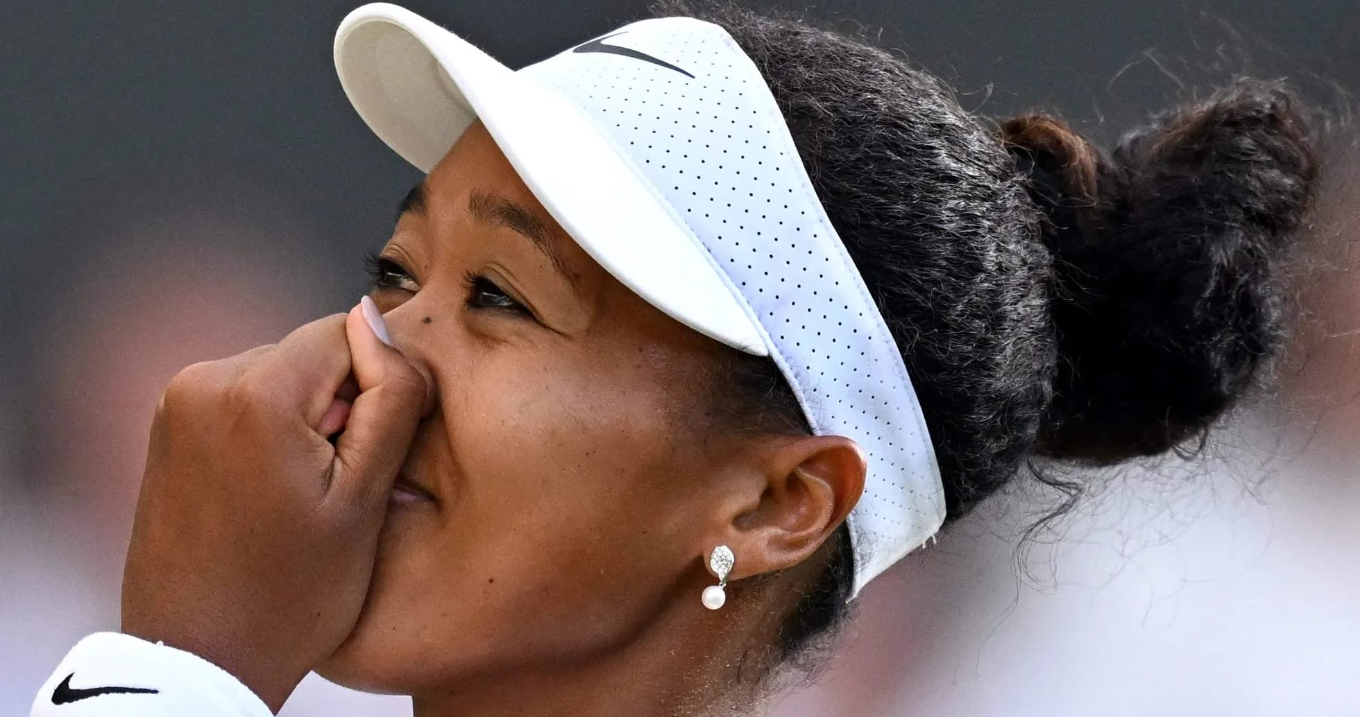 Naomi Osaka cubriendo su rostro con la mano