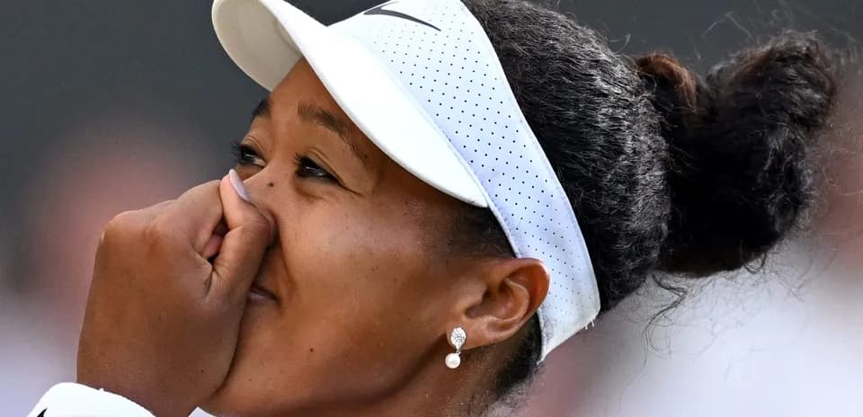Naomi Osaka cubriendo su rostro con la mano