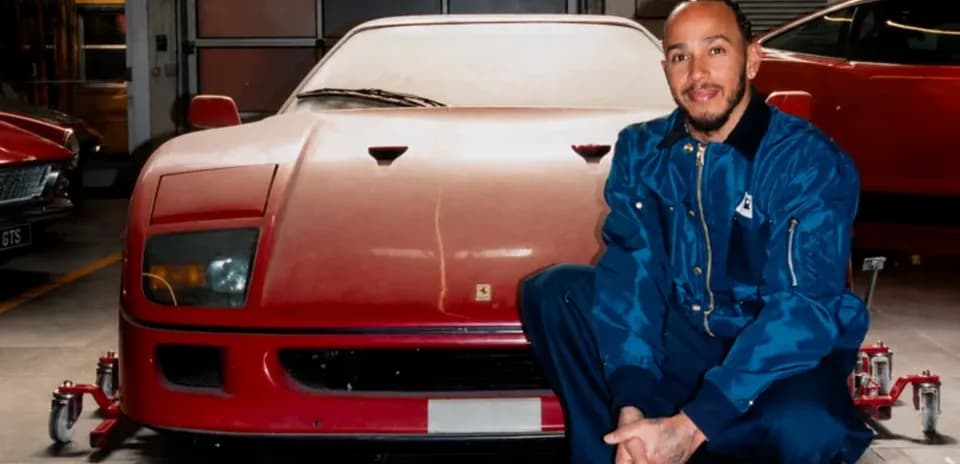 Hombre posando junto a un coche rojo en taller