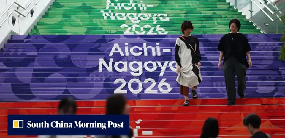 Dos personas bajando escaleras decoradas con Aichi-Nagoya 2026
