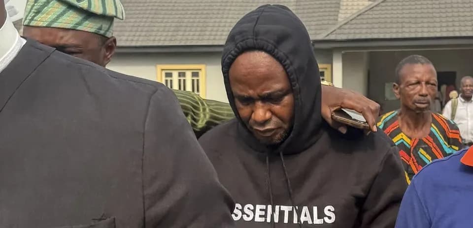 Hombre con sudadera negra rodeado de personas en la calle