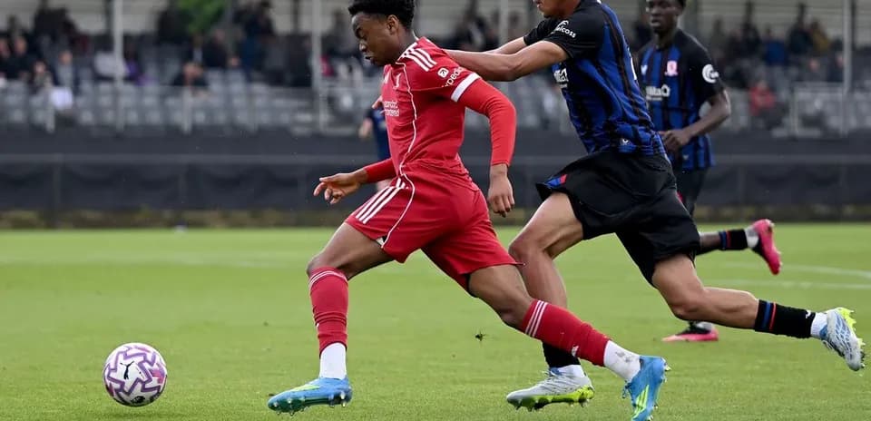 Jugador de Liverpool driblando a un oponente en el campo