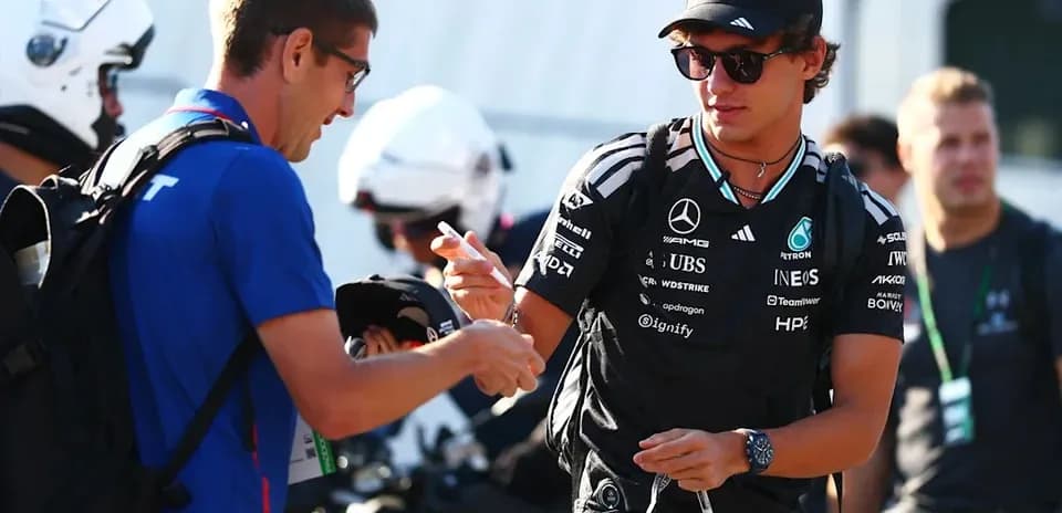 Piloto de Mercedes firmando autógrafo para un fan