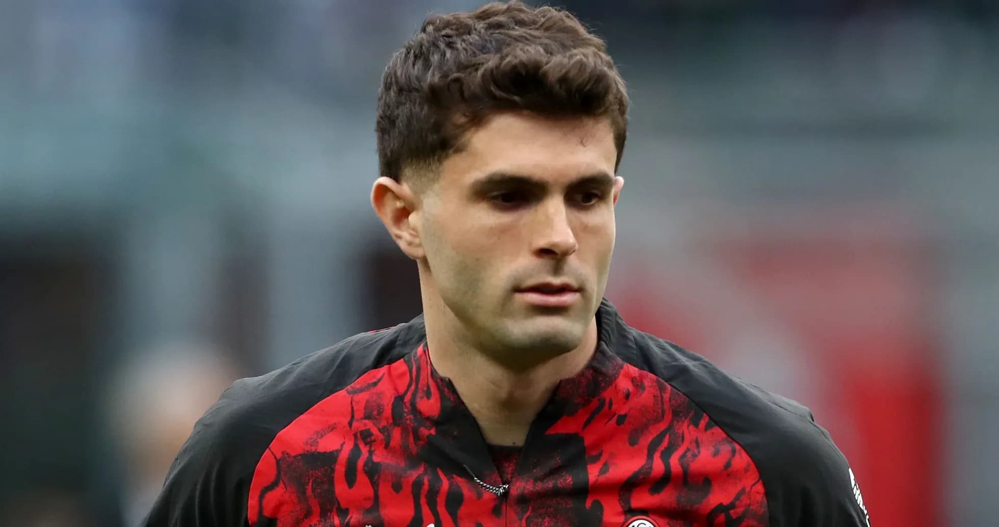 Jugador con camiseta del AC Milan caminando en el campo