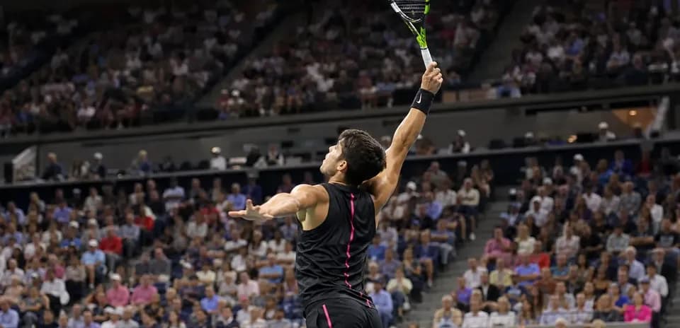 Jugador de tenis sirviendo en partido ante público