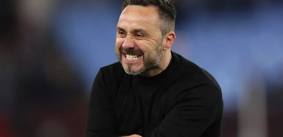Entrenador sonriendo durante el partido en el banquillo