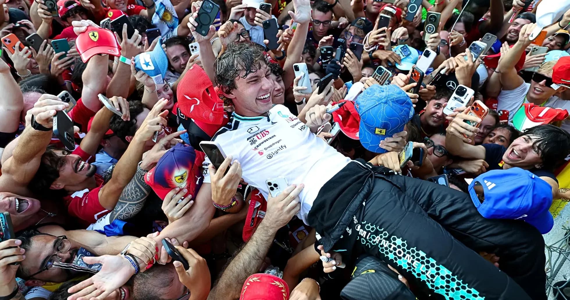 Piloto rodeado de fans celebrando su victoria