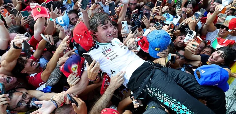 Piloto rodeado de fans celebrando su victoria