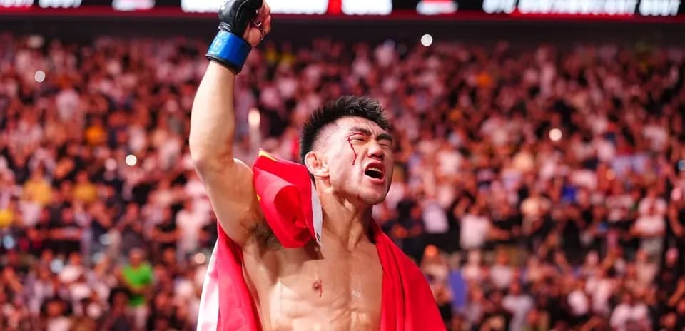 Luchador levantando la mano con una bandera roja