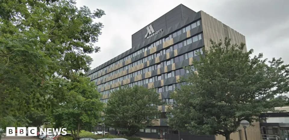 Edificio Marriott rodeado de árboles y autos