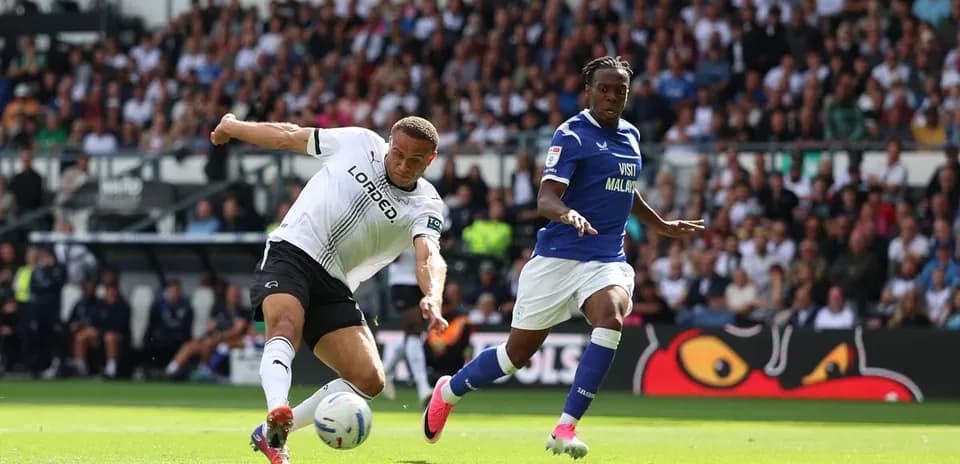 Jugador de Derby County deslizándose por el balón