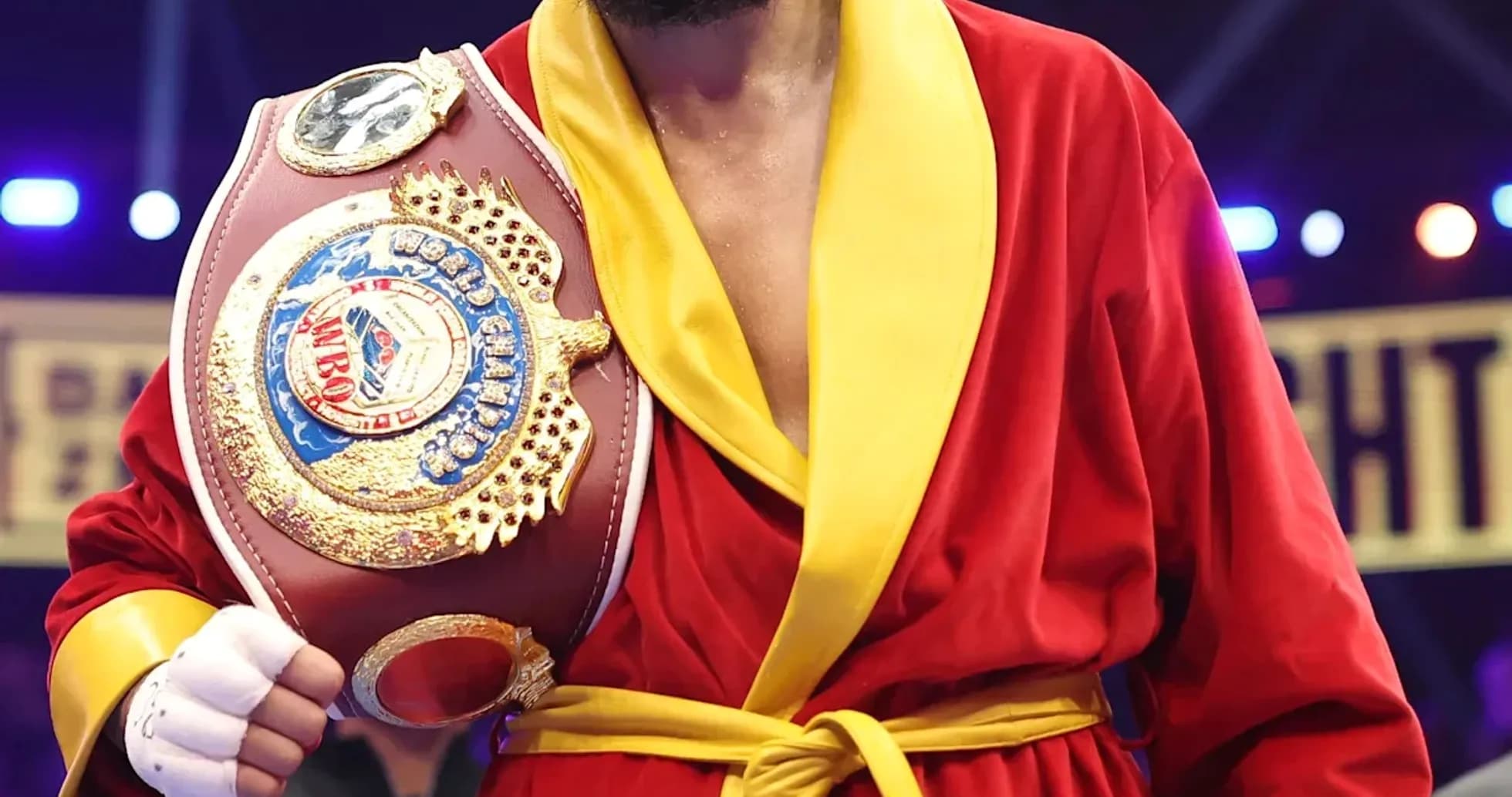 Boxeador sosteniendo cinturón en el ring