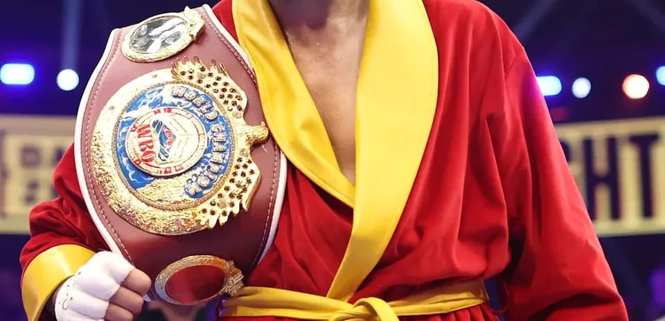 Boxeador sosteniendo cinturón en el ring