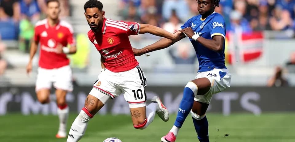 Jugador de Manchester United esquivando a rival de Everton