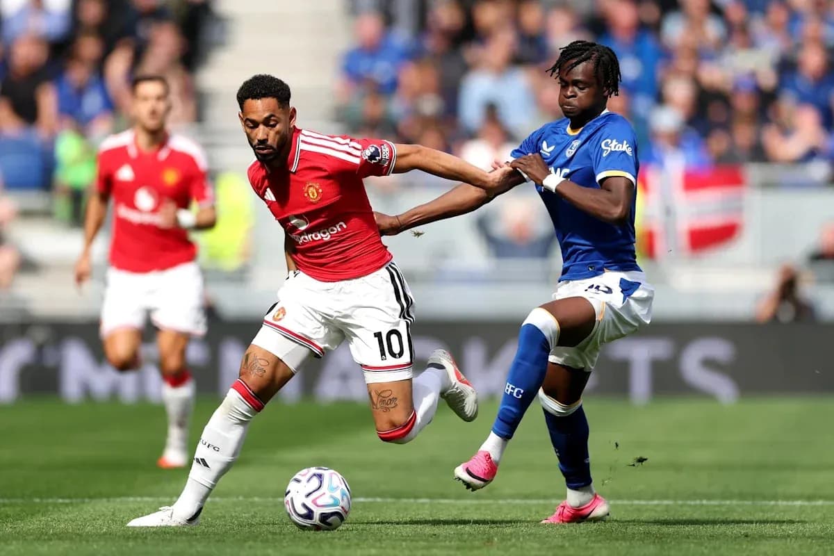 Jugador de Manchester United esquivando a rival de Everton