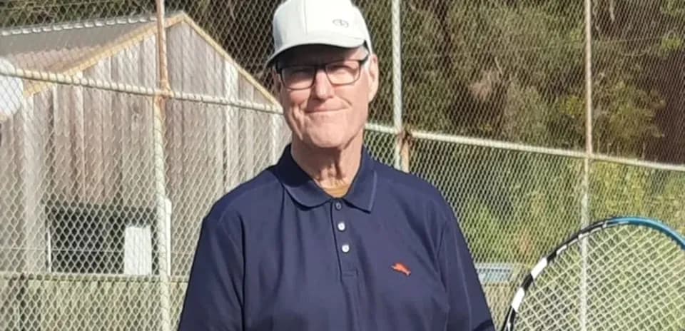 Hombre con raqueta de tenis en cancha al aire libre