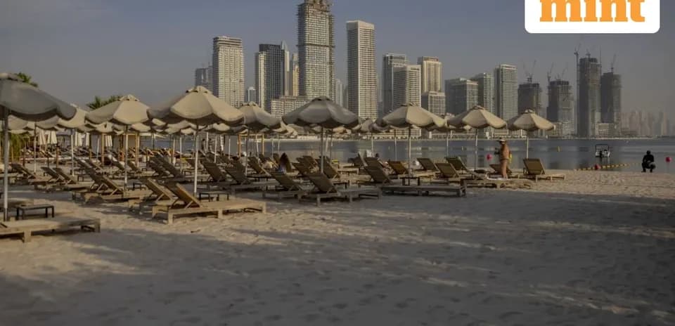 Playa con tumbonas y edificios altos al fondo