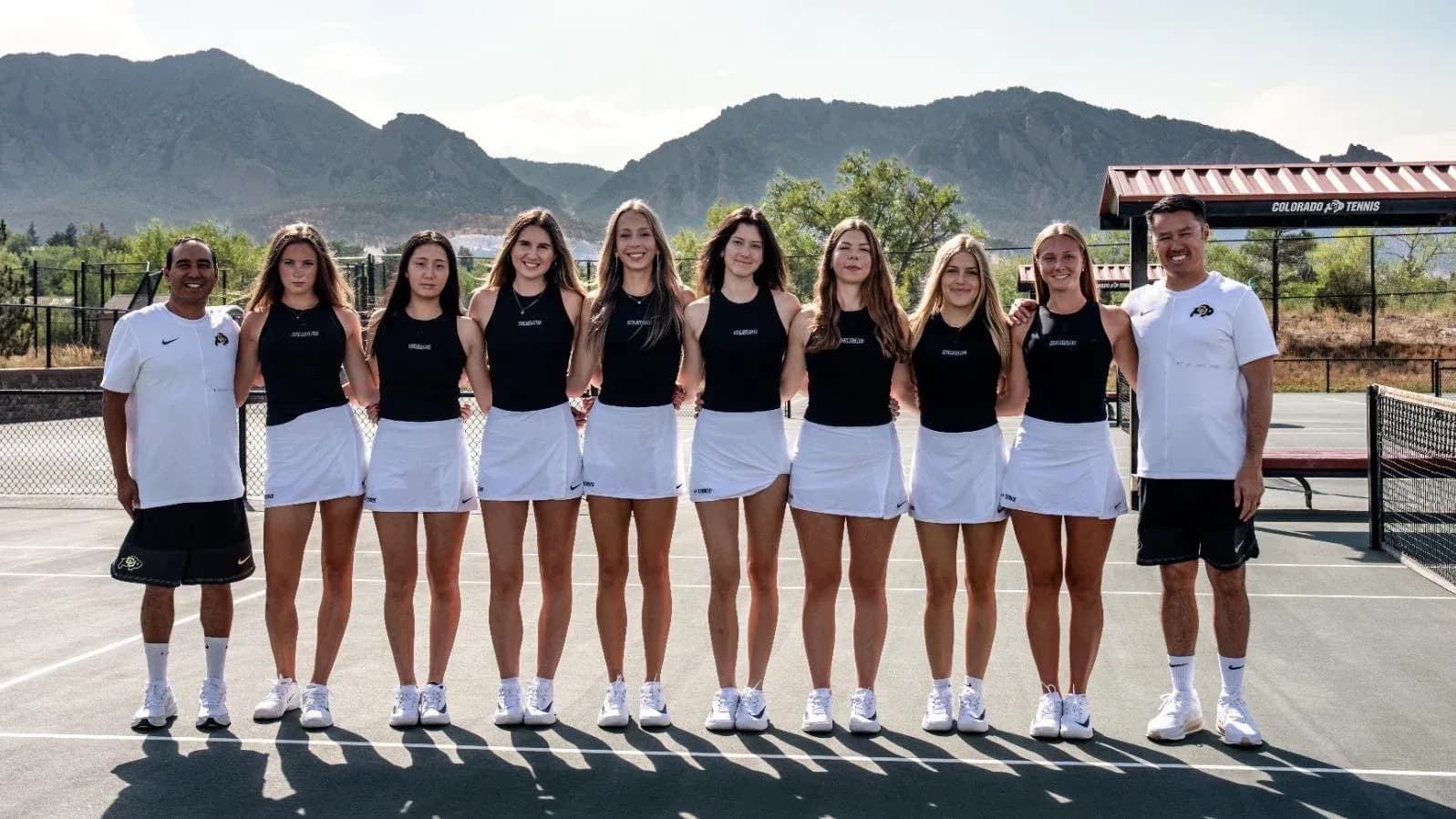 Equipo de tenis femenino posando en la cancha